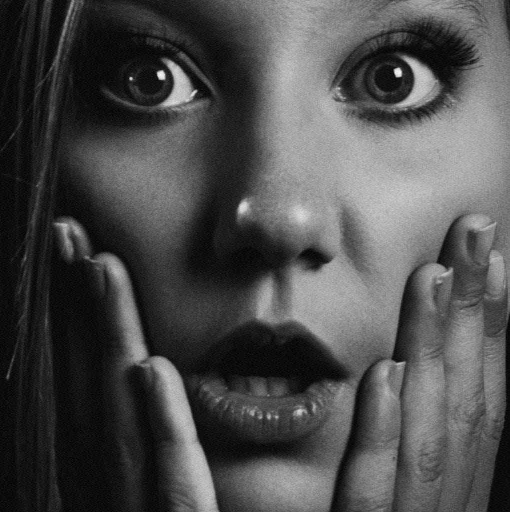 Woman's surprised face up close grayscale
