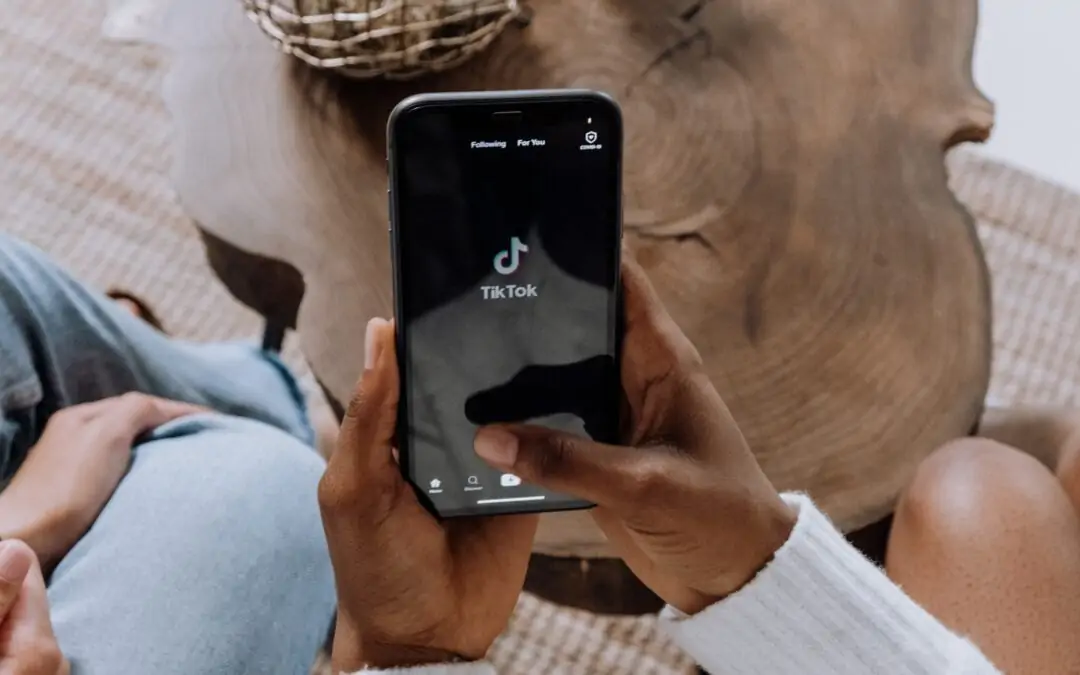 woman holding phone with tik tok logo