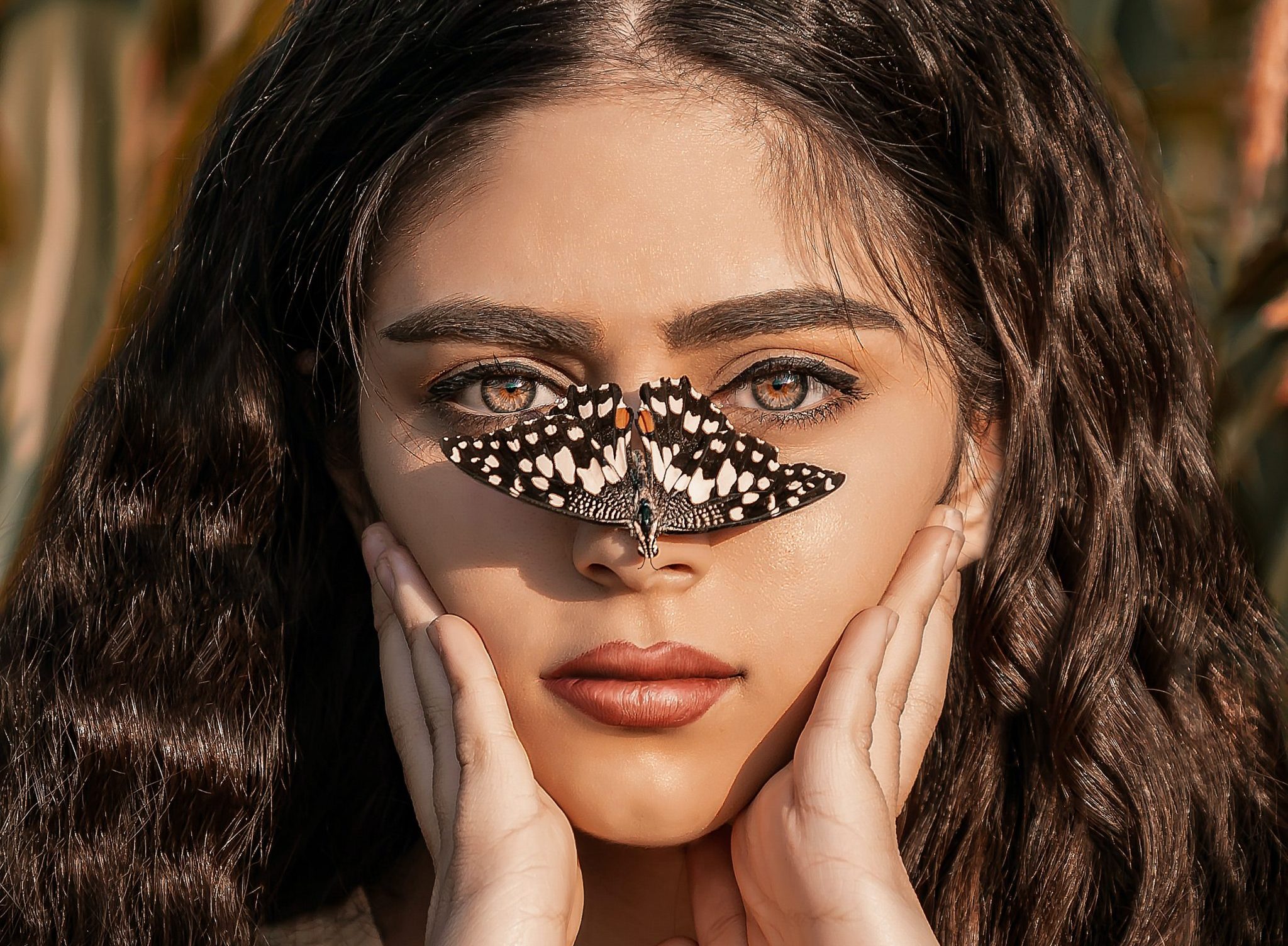 girl with brown hair and brown eyes with a butterfly on her nose