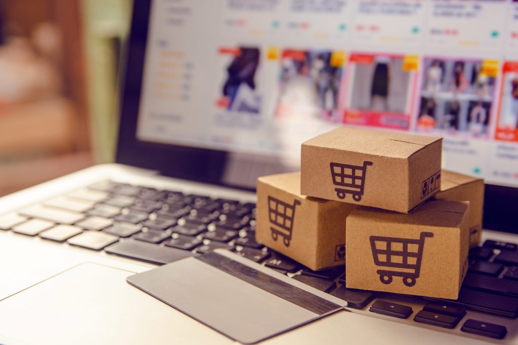 Shopping online concept - Shopping service on The online web. with payment by credit card and offers home delivery. parcel or Paper cartons with a shopping cart logo on a laptop keyboard. Holiday online shopping